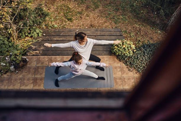pregnant mother and daughter doing yoga in nature